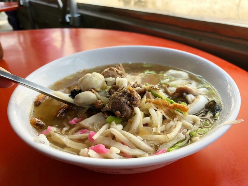 東港美食｜東港飯湯│阿扁飯湯，碗裡滿滿的鮪魚、蝦、花枝、魚丸、蚵仔…等豐盛配料，淋上一匙肉燥提味，滋味豐富厚實