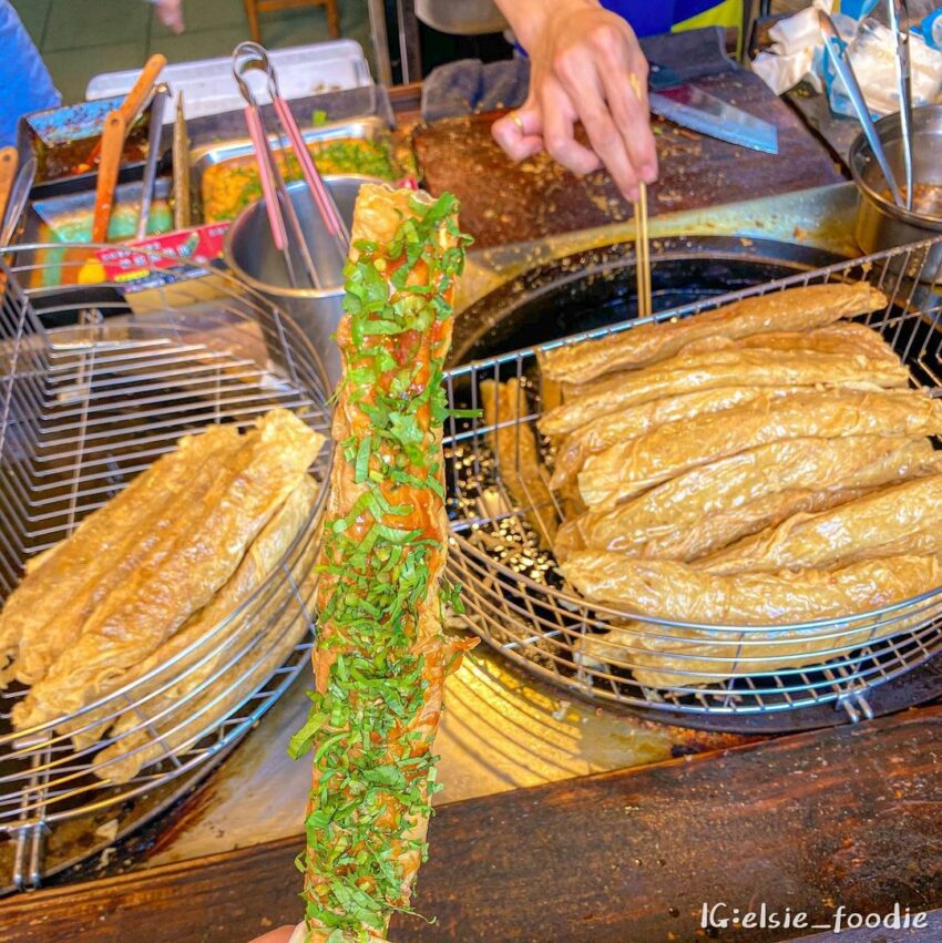 日月潭美食|必吃特色小吃,總統魚酥捲位於「三豎一橫」街道中,三豎的中間巷子裡,魚酥捲外皮為薄薄的腐皮,裹著用總統魚做的新鮮魚漿,現點現炸,外皮金黃酥脆,內餡著冒著熱氣,有著魚漿的鮮甜與Q彈口感,串上竹籤再淋上特製醬汁和香菜,方便拿著邊吃邊欣賞日月潭美景。 日月潭美食|必吃特色小吃,總統魚酥捲位於「三豎一橫」街道中,三豎的中間巷子裡,魚酥捲外皮為薄薄的腐皮,裹著用總統魚做的新鮮魚漿,現點現炸,外皮金黃酥脆,內餡著冒著熱氣,有著魚漿的鮮甜與Q彈口感,串上竹籤再淋上特製醬汁和香菜,方便拿著邊吃邊欣賞日月潭美景。